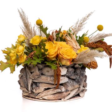 Floral arrangement in basket with craspedia and spray roses