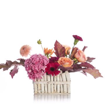 Floral arrangement in basket with roses and hydrangea