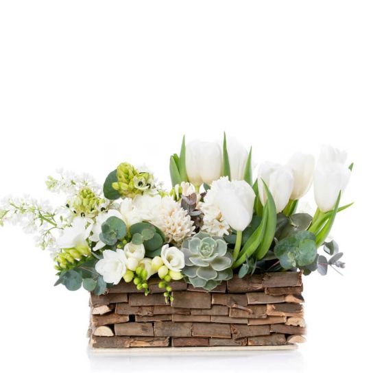 Floral arrangement in basket with lilac and white freesias