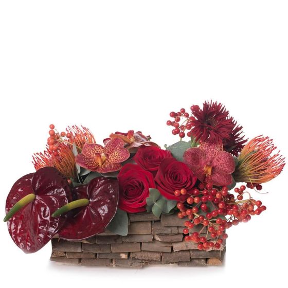 Floral arrangement in basket with anthurium grena and orchids