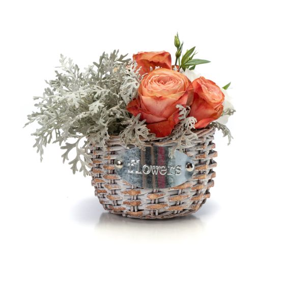Floral arrangement in basket of roses and lisianthus