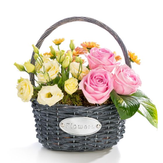 Floral arrangement in basket of roses, lisianthus, chrysanthemum