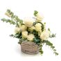 Floral arrangement in basket made of white roses, ruscus