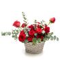 Floral arrangement in basket from red roses, ruscus