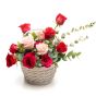 Floral arrangement in basket of pink roses, cyclamen, tomatoes