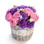 Floral arrangement in basket of pink roses, purple lisianthus